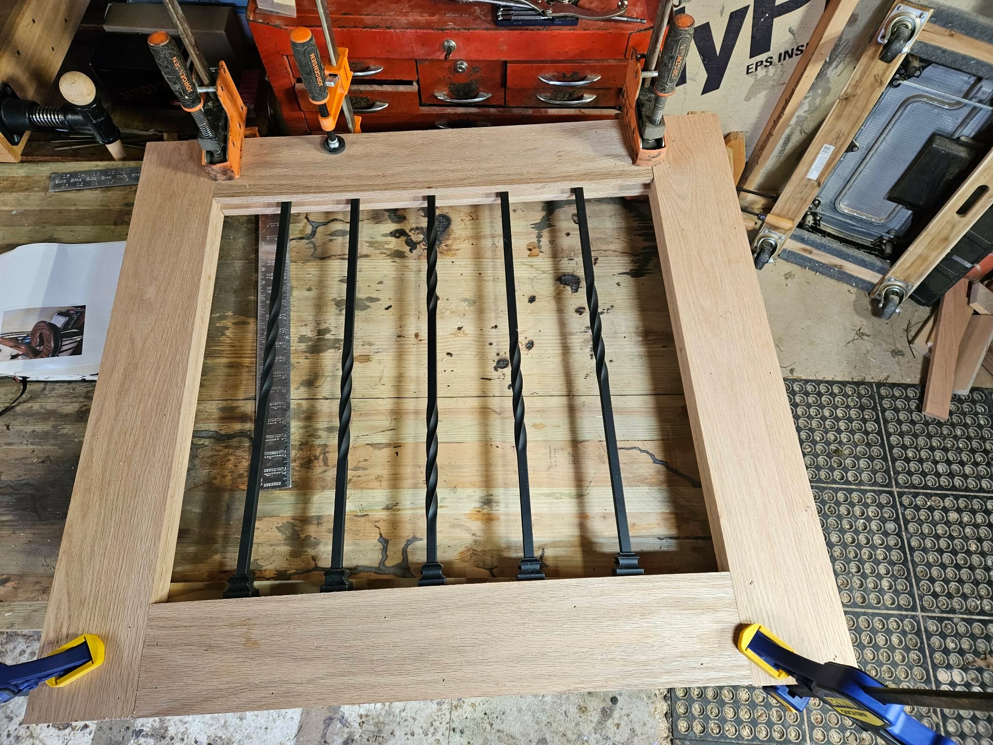 Custom iron and wood railing panel being built in workshop