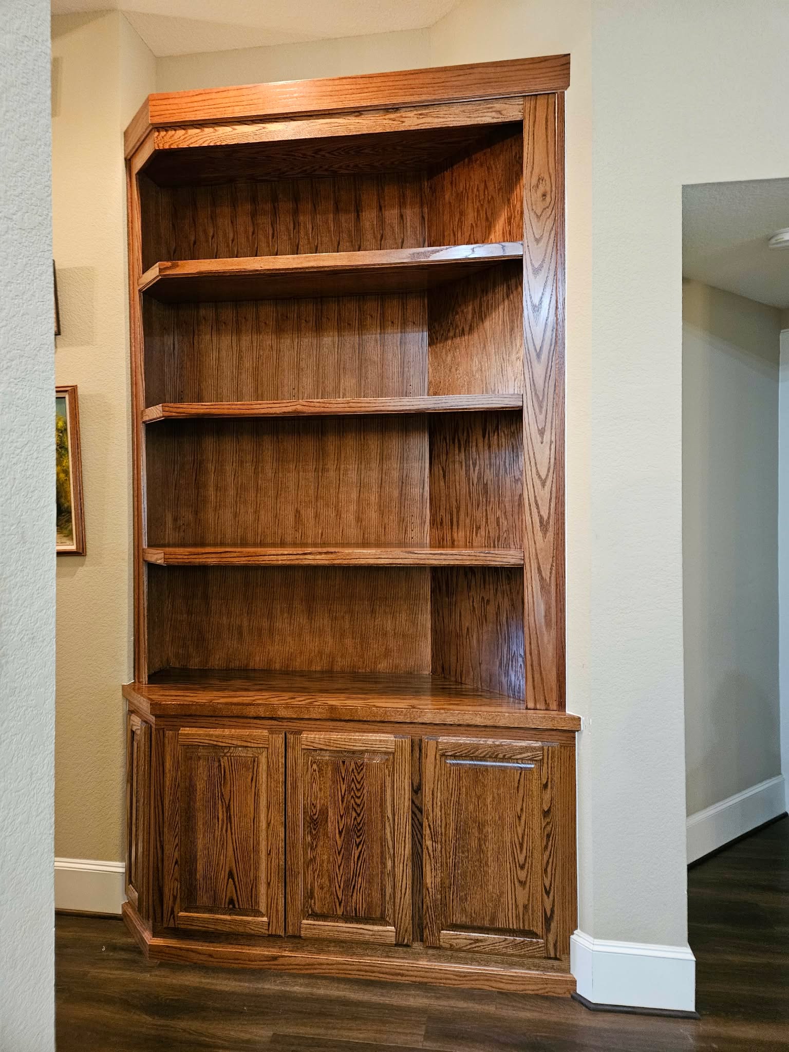 Beautiful custom oak corner bookcase cabinet installed in home