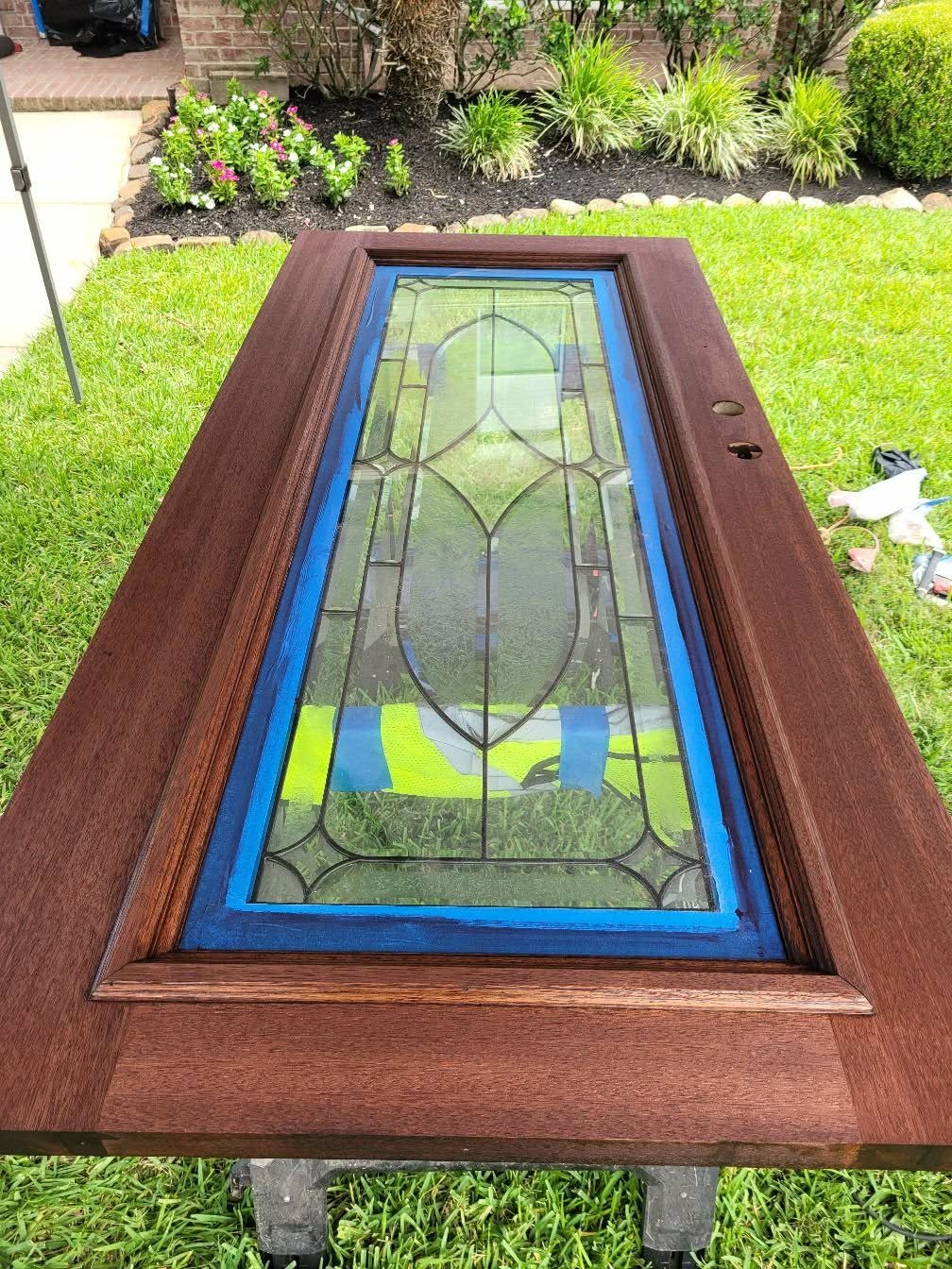 Custom wood door with leaded glass panel being refinished